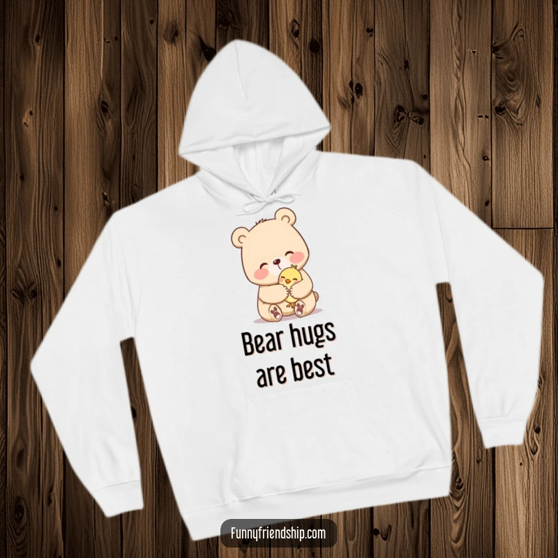 Funny hoodie depicting a large bear character offering a strong, comforting hug to a small bird. Cozy and heartwarming.